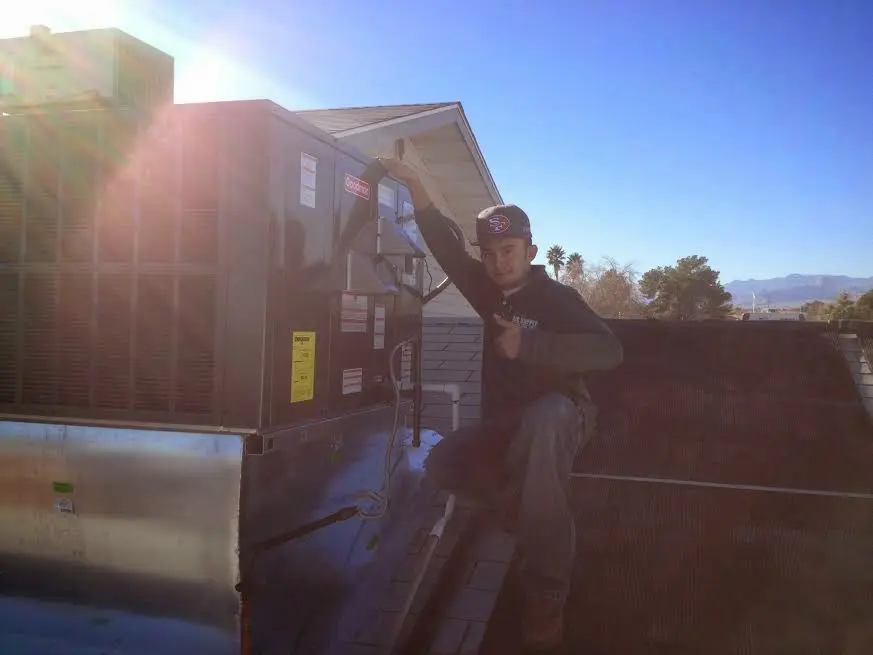 HVAC technician performing Air Duct Repair on a rooftop unit in Caribou